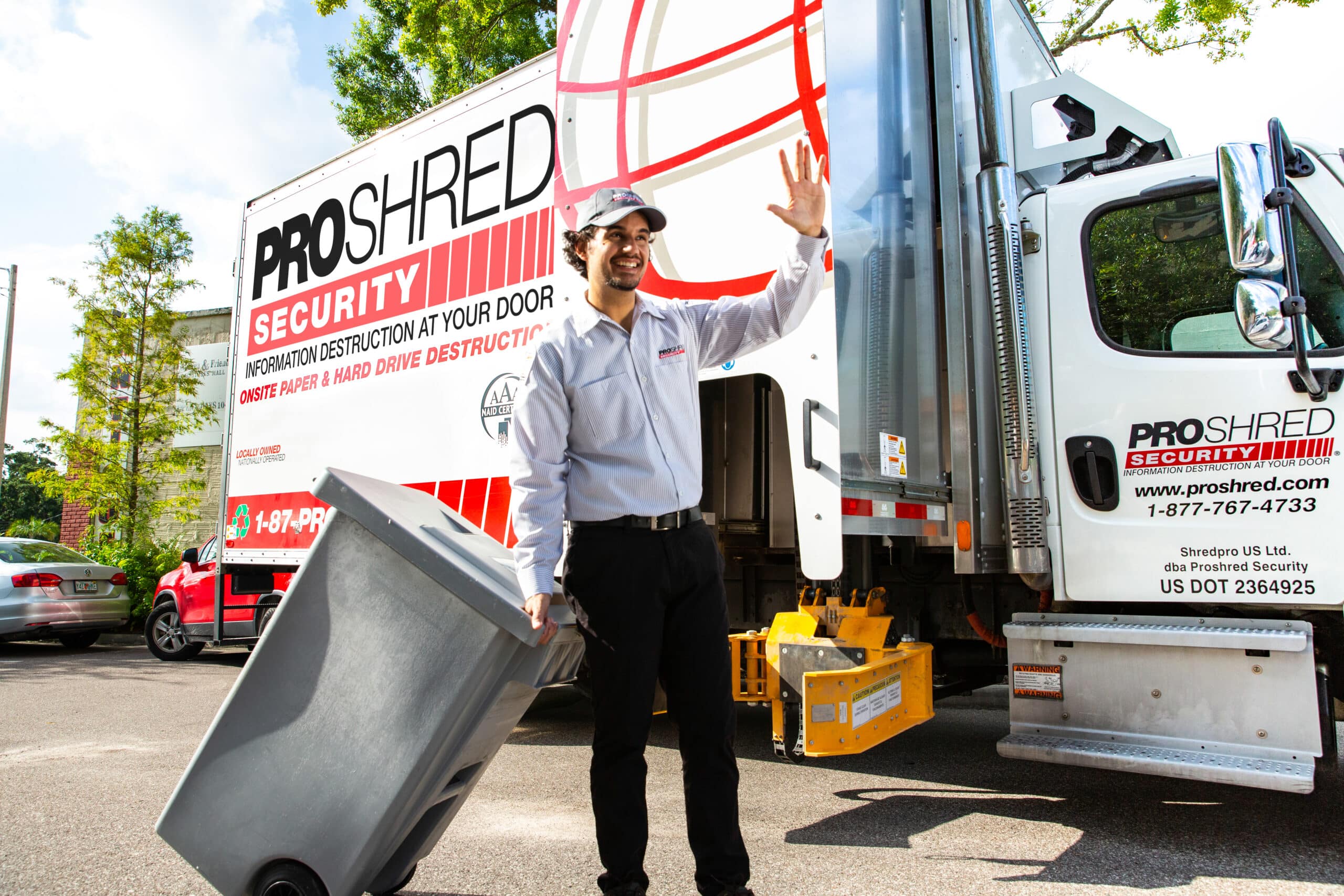 Employee pushing a shredding bin through an office. 