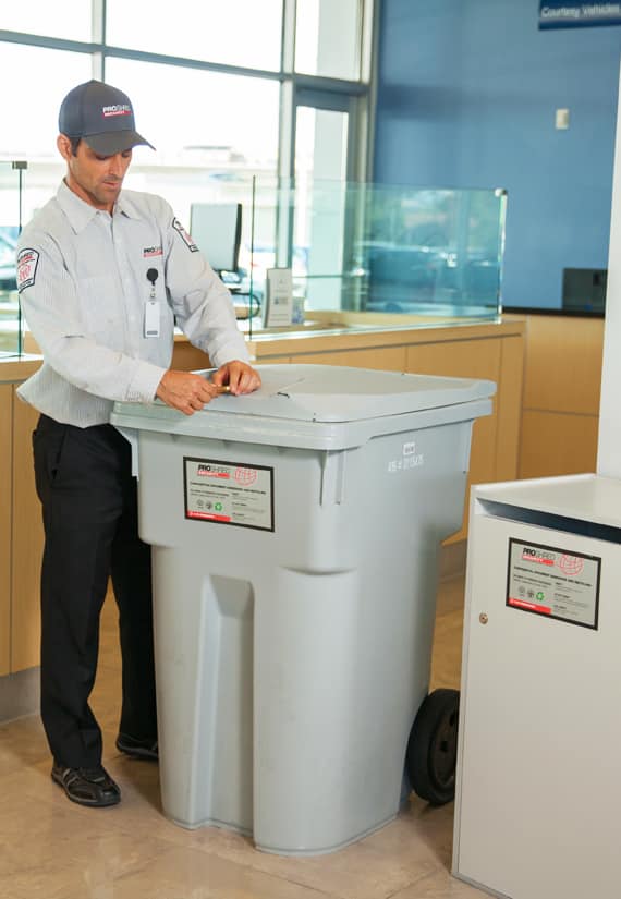 Proshred employee locking the high volume Secure console bins